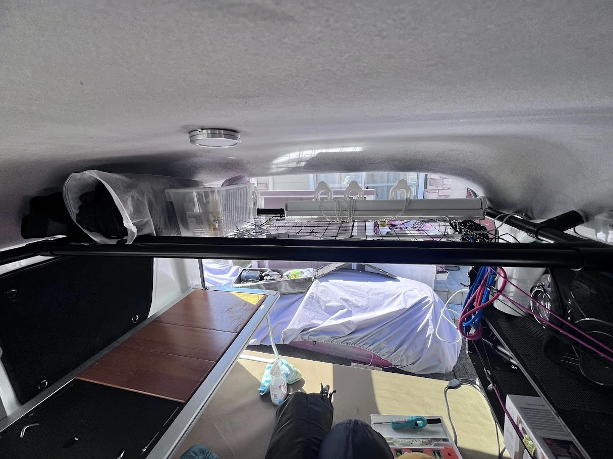 軽バンの天井収納に100均のケースを使って小物を整理している様子