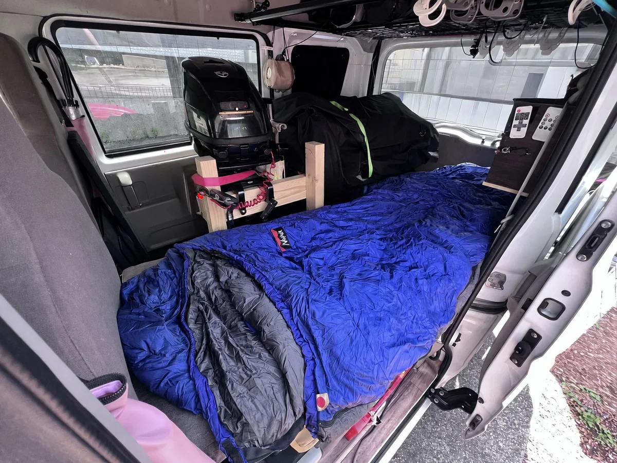 軽バンにゴムボートを積んだまま片側に寝床を確保している車中泊レイアウト