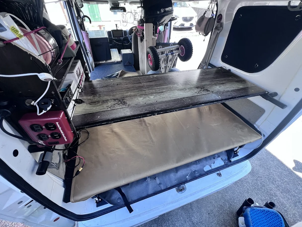 軽バン車中泊のリア棚収納。ベッド上に棚板を渡して荷物置き場を作った実例